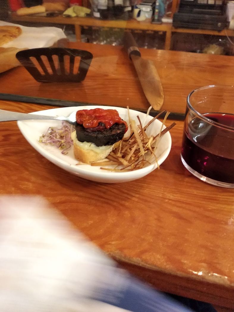 Montadito de morcilla con tomate y patatas paja.