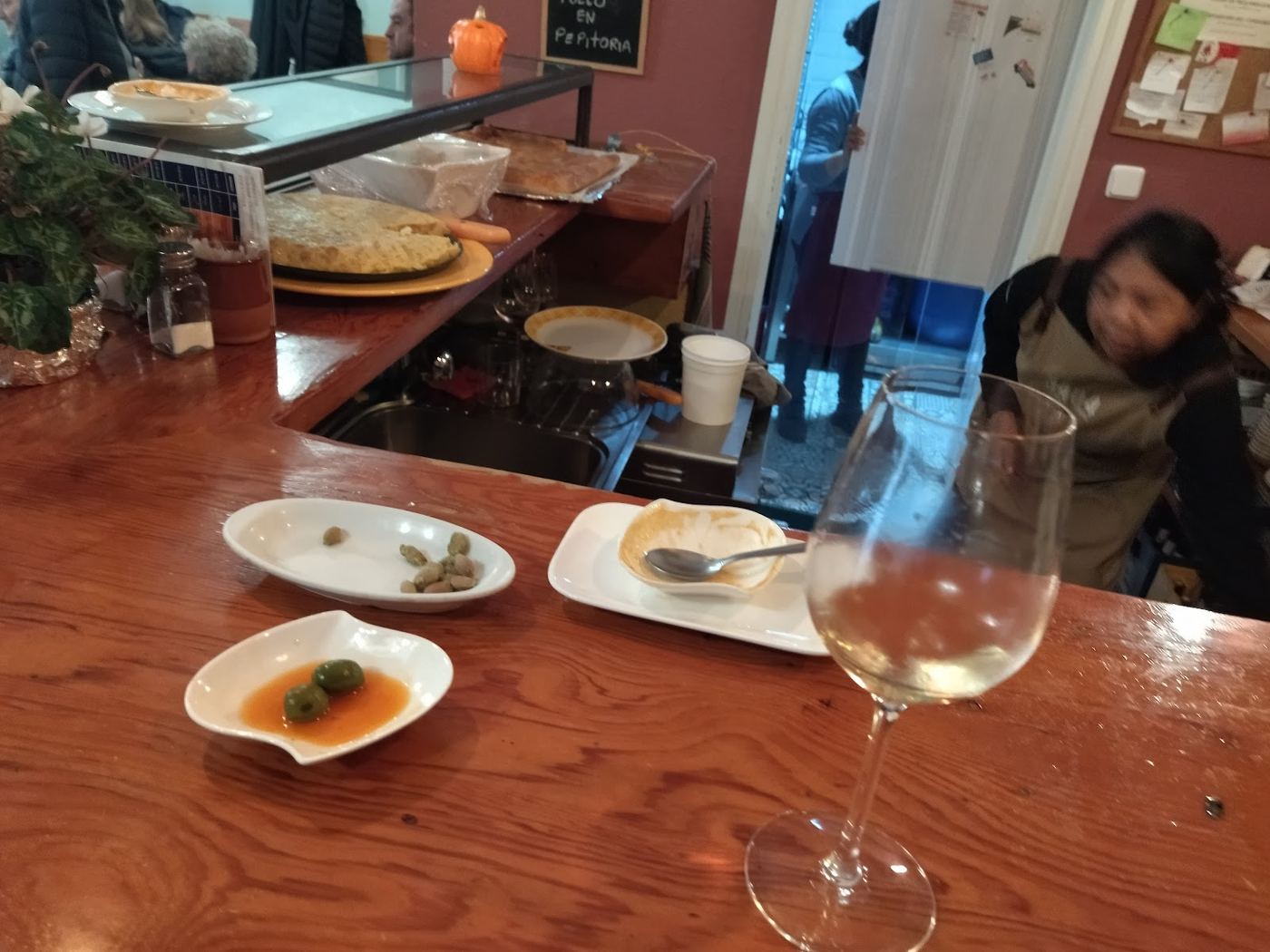 Barra de La Abadía con botellas de vino y ambiente informal.